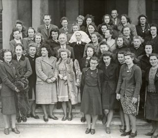 Diplomātiskā dienesta vadītājs, sūtnis un ārkārtējo pilnvaru nesējs Kārlis Zariņš (otrajā rindā vidū) sagaida pirmo latviešu bēgļu grupu no Vācijas. Londona, 1946. gada 19. oktobris. Avots: Latvijas Ārlietu ministrijas arhīvs.