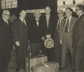 Kārlis Zariņš ierodas Ņujorkā ASV saistībā ar sūtņa Feldmaņa nāvi, 1953. gads. Sagaida no kreisās: dziedonis Emīls Mauriņš, Anatols Dinbergs (lietvedis), Vilis Masēns, Arvīds Bļodnieks, Alfrēds Bērziņš, Ādolfs Klīve. Avots: LNA_LVA, F2263_1_252, 4. lp.