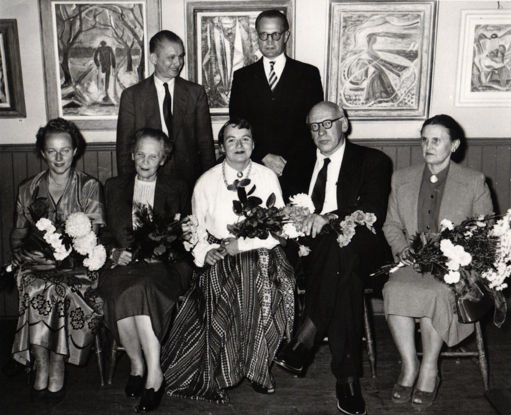 Latviešu Preses biedrības Kanādas kopas rakstnieku cēliena dalībnieki. 1. rindā no kreisās: 1. Ingrida Vīksna, 2. Angelika Gailīte, 3. Karola Dāle, 4. viešņa no ASV, 5. Mariss Vētra, 6. Biruta Senkēviča; 2. rindā no kreisās: 1. Viktors Upeslācis, 2. Heronims Tihovskis. Aizmugurē pie sienas redzamas mākslinieka Arnolda Nulīša gleznas. Kanāda, 20. gs. 60. gadi. Avots: LNA_LVA_F2402_US2