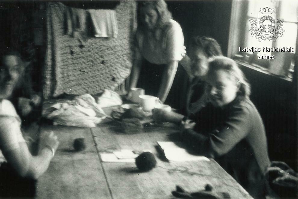 Četras sievietes, Gotenhāfenas (tagad - Polija, Gdiņa) ostas Darba pārvaldes Austrumu Strādnieku pagaidu nometnes barakā, sēž pie galda un ada. Foto: Leopolds Sīpoliņš. Avots: LNA_KFFDA_F181_1_231