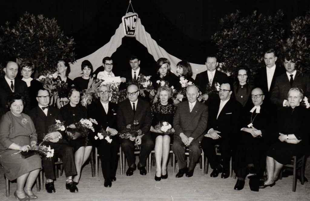 Minsteres ģimnāzijas 18. izlaiduma audzēkņi un pasniedzēji. 1. rindā 1. no labās puses Aina Šilde. 1964. gads. Avots: LNA_LVA_F2335_1v_391, 59. lp.