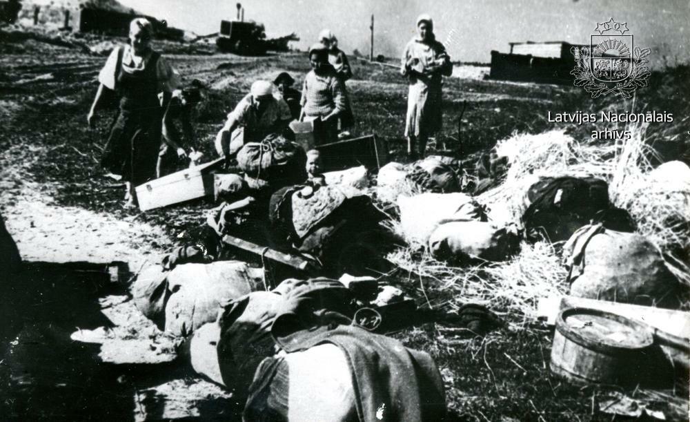 Bēgļu gaitas, ceļa malā sievietes ar bērniem pie mantu kaudzes. 1944. gads. Foto: V. Grebņevs. Avots: LNA_KFFDA_F1_4_43970.